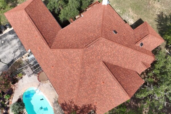 Aerial view of residential house featuring beautiful red, energy-efficient asphalt shingles.